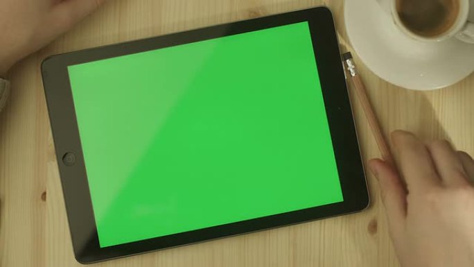 桌子上放着绿色屏幕的平板电脑