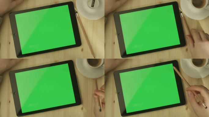 桌子上放着绿色屏幕的平板电脑
