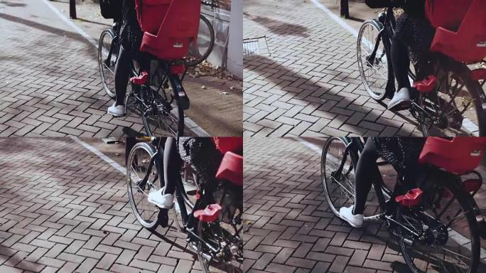 踏板上的慢动作脚特写。城市自行车休闲骑在街上的幸福女人