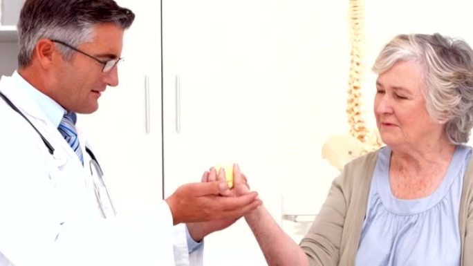 医生向患者展示如何锻炼受伤的手