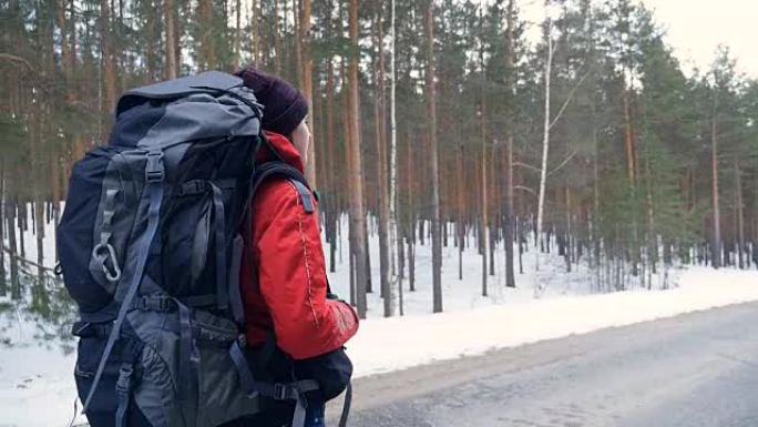 女人背着背包在美丽的冬季森林徒步旅行。斯蒂安卡姆开枪。