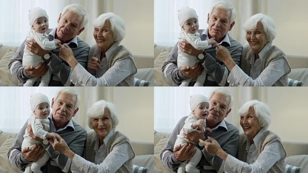 带着婴儿看着相机的祖父母