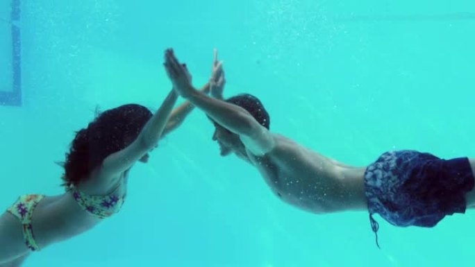 幸福的情侣手牵着手一起跳进游泳池