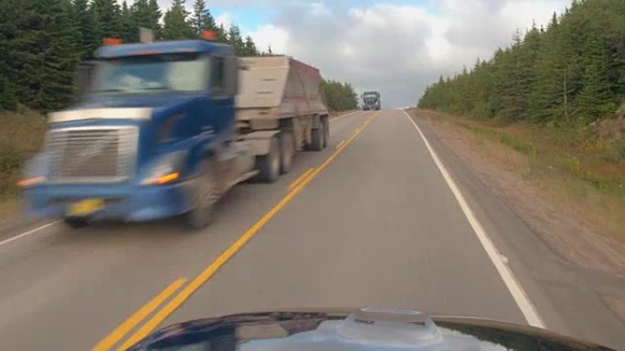 FPV: 沿着加拿大针叶树林地的高速公路行驶，经过半卡车