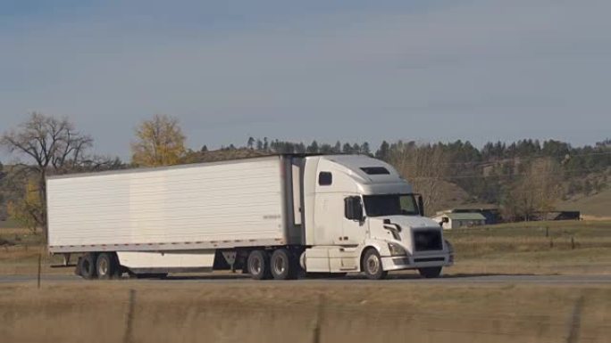 关闭白色半卡车运输货物穿越美国乡村公路