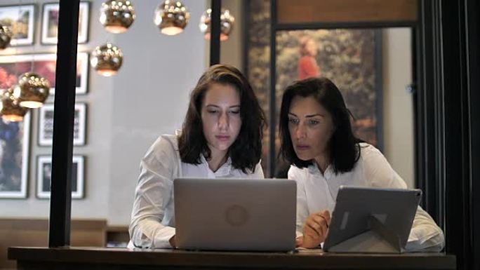两个人在咖啡馆使用笔记本电脑