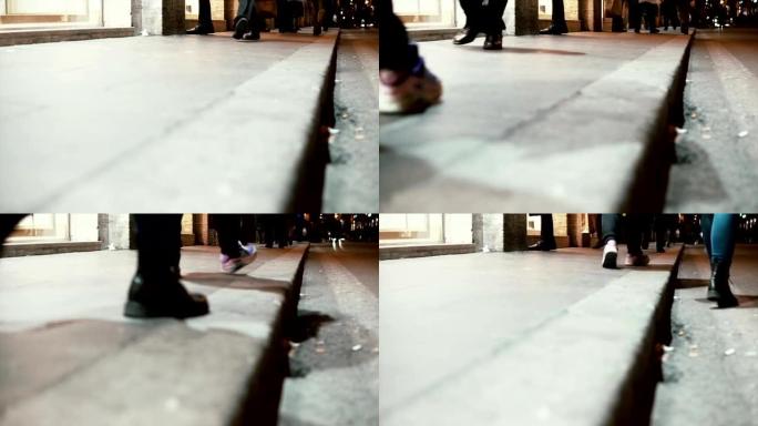 晚上市中心人行道的特写镜头。行人快点走。慢动作