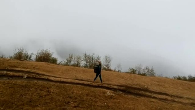 山地冒险。年轻女子在草地上旅行