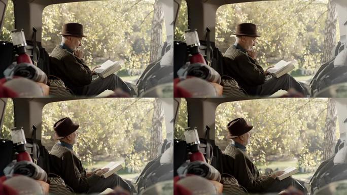 坐在汽车后面看书的高级男子