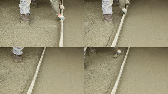 工人使用手动找平层和镘刀抹平混凝土