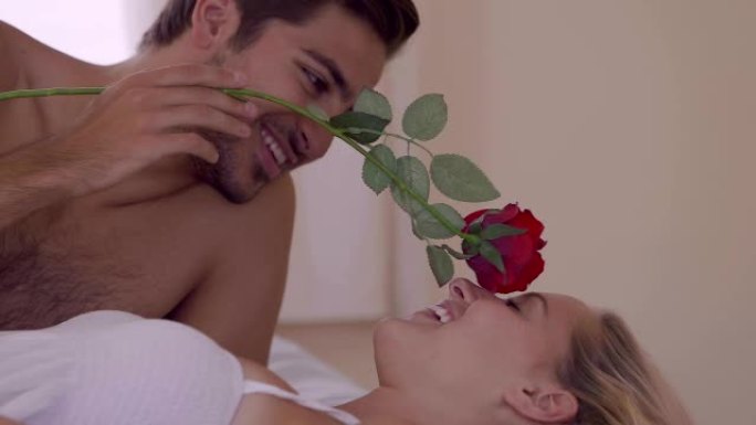 男人在床上用红玫瑰挠痒痒