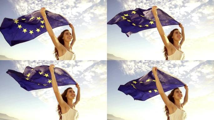 欧洲妇女举着欧盟旗帜对抗天空飘扬