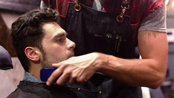 男人用修剪器修剪胡须
