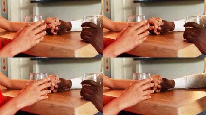 夫妇在柜台喝威士忌时握着他们的手