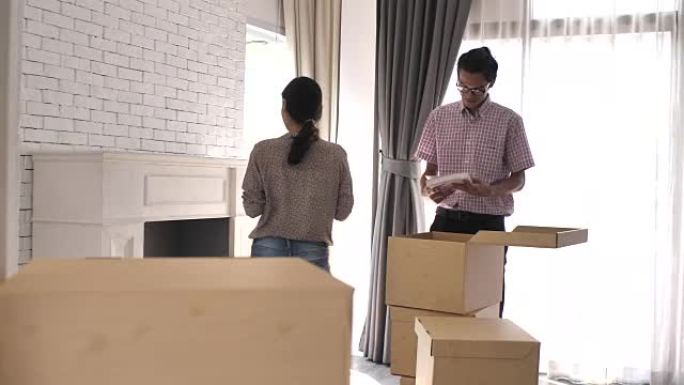 亚洲夫妇在搬家日在新家中开箱