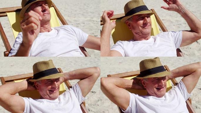 高级男子在海滩的沙滩椅上放松