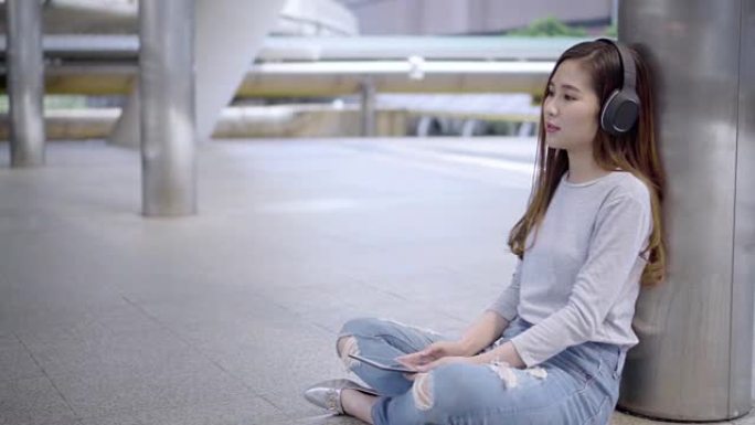 一个坐着听音乐的年轻女子。