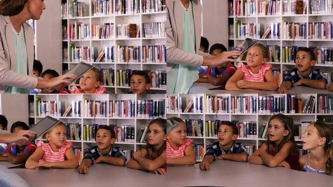 教师在图书馆的数字平板电脑上教学校的孩子