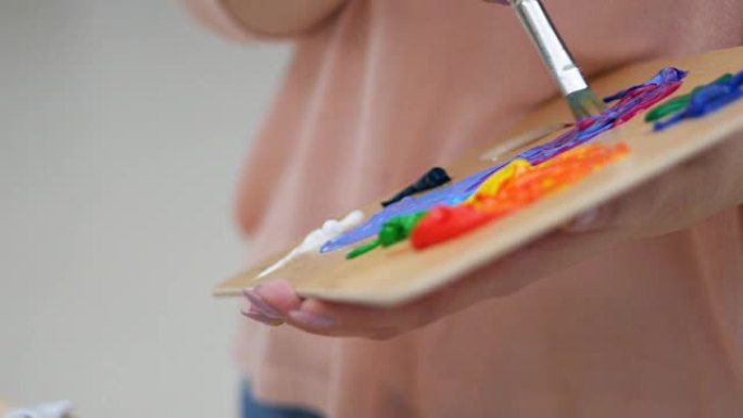 艺术家用刷子特写混合颜色。