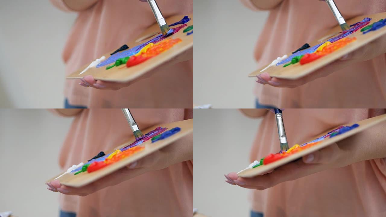 艺术家用刷子特写混合颜色。