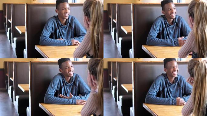 跨种族少女夫妇在餐厅摊位聊天