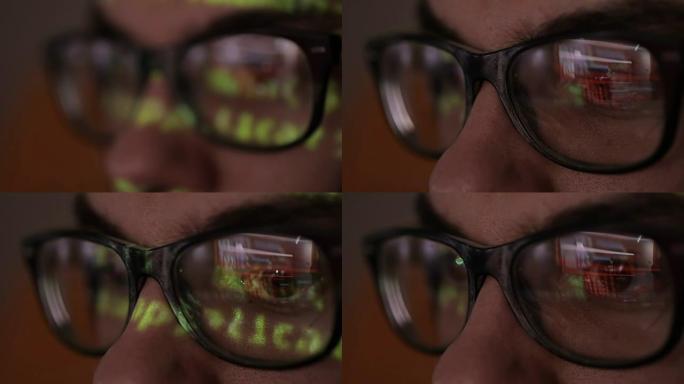 黑客用二进制代码屏幕，数据代码反射在程序员的眼镜中