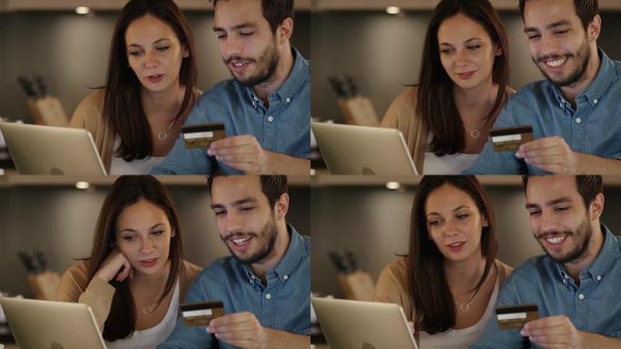 年轻夫妇使用信用卡在笔记本电脑上购买东西。