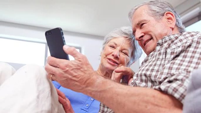可爱的老年夫妇使用智能手机