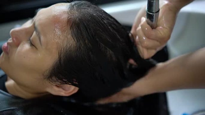 亚洲女性在沙龙洗头。