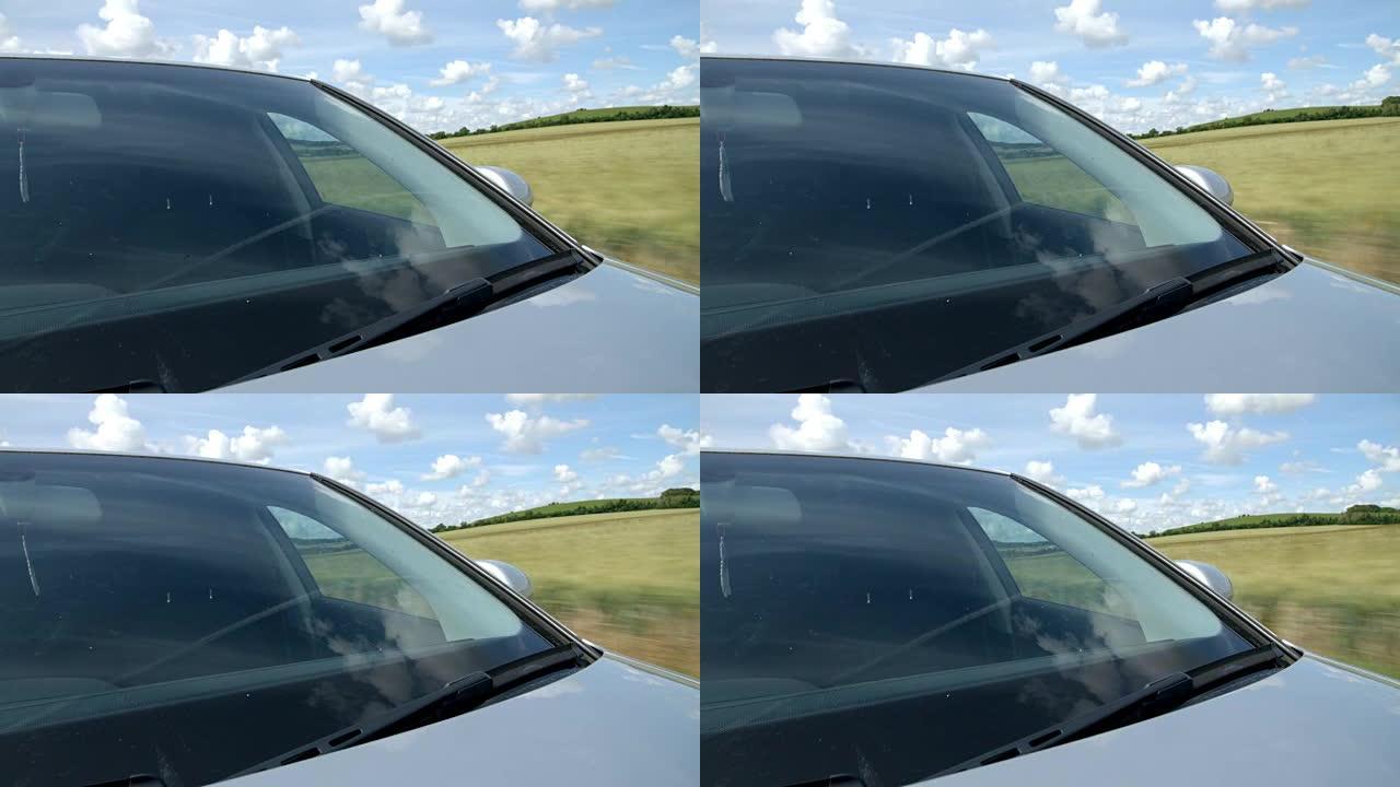 在乡村道路上行驶的汽车的外部挡风玻璃特写