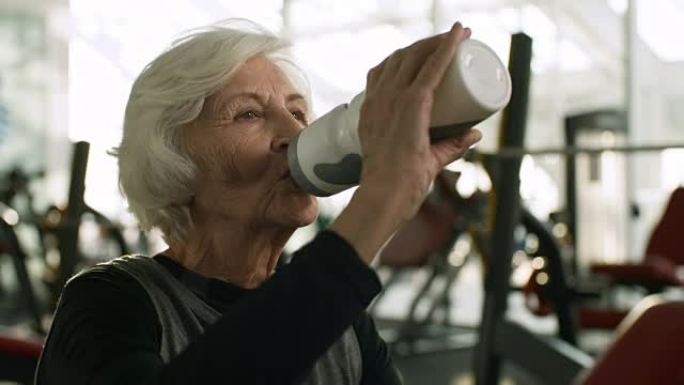锻炼后的老年妇女喝水