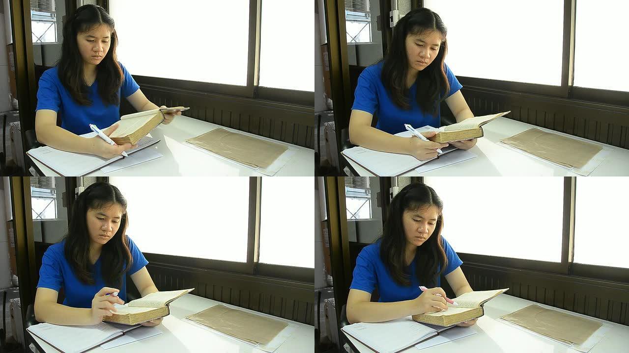 泰国女学生拿着书看书。