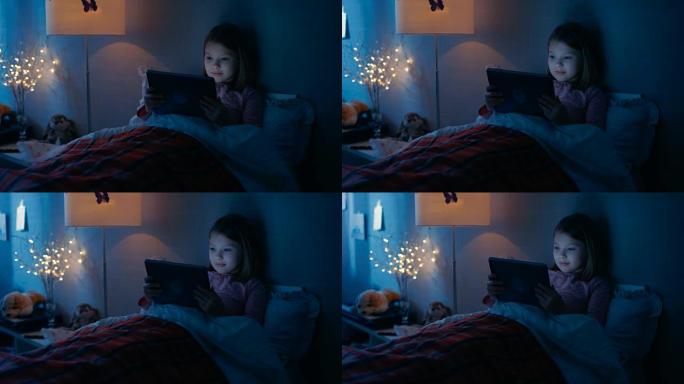 卧室里可爱的小女孩躺在床上，放着平板电脑。