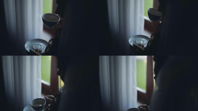 黑发女人看着远处喝茶的特写镜头。女性独自在家度过早晨