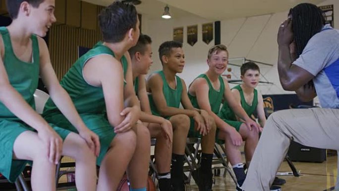 非裔美国教练在和一群年轻篮球运动员谈话
