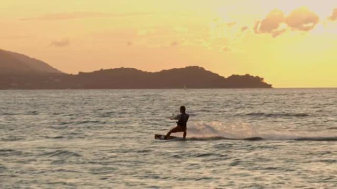 日落时在海湾冲浪的风筝冲浪者的SLO MO剪影