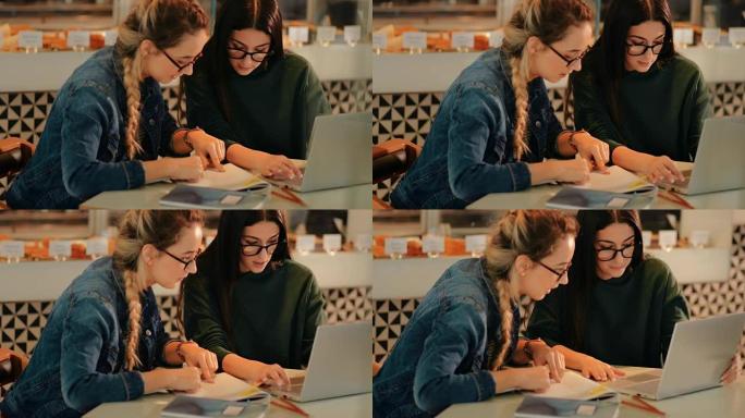 年轻的时髦女性带着笔记本电脑在咖啡馆上大学学习