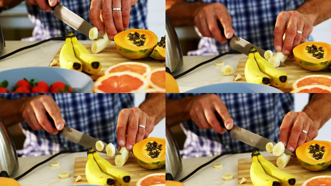 男人在厨房工作台上切香蕉的中间部分