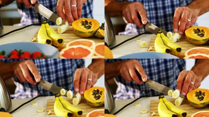 男人在厨房工作台上切香蕉的中间部分