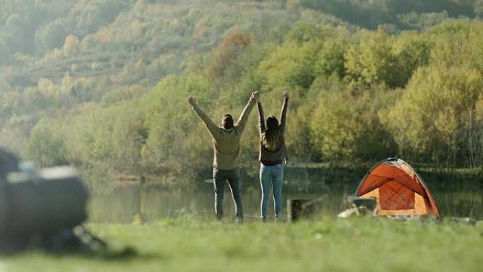 男人和女人走到湖边，举起手来