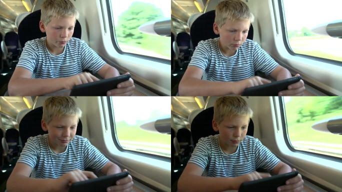 男孩在火车旅行中阅读电子书