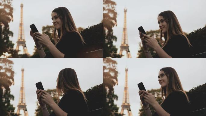 美丽的年轻女子使用智能手机。快乐女性坐在法国巴黎埃菲尔铁塔附近的长凳上