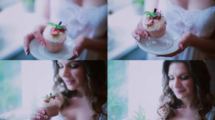 碟子上漂亮纸杯蛋糕的特写镜头。女人拿着一盘蛋糕，闻起来是甜点