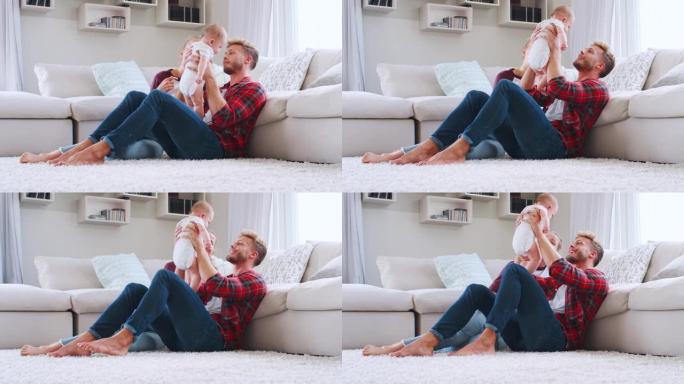 年轻的白人夫妇坐在家里举起婴儿，侧视