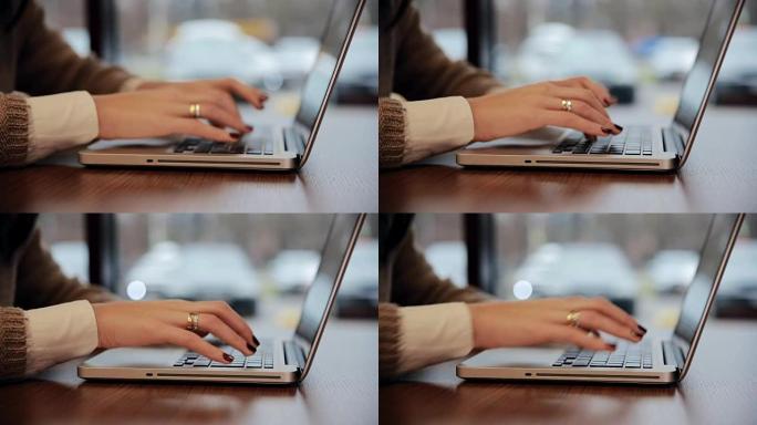 咖啡馆里的女性手在笔记本电脑上工作。静态