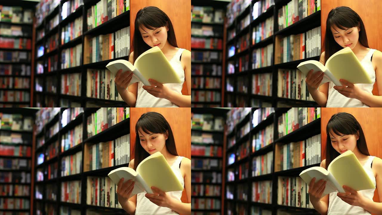 漂亮的年轻女子在图书馆看书