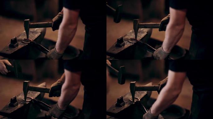 两个男人用锤子一起做马蹄铁。铁匠在工作场所的围裙中使用热金属