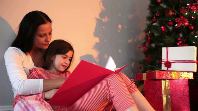 母亲在圣诞树旁读女儿的故事