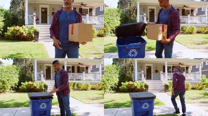 男子将纸板放入郊区街道的回收箱中