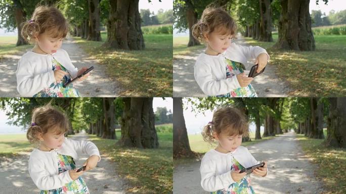 慢动作: 好奇的小女孩在爸爸的智能手机上观看有趣的卡通。